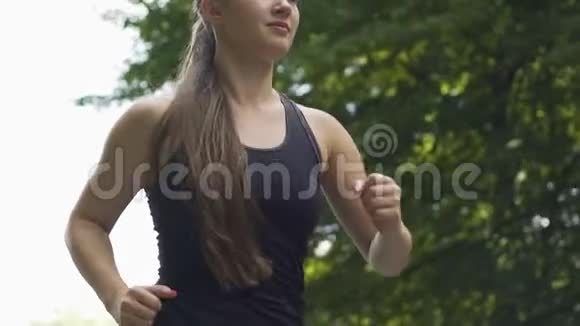 慢动作的年轻女子在户外跑步长发的女性慢跑公园视频的预览图