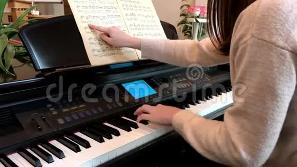 坐在钢琴旁学习音乐的女孩视频的预览图