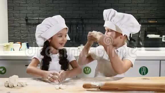 孩子们一起做饭时玩得很开心孩子的厨房孩子们戴着厨师帽玩面团4k视频的预览图