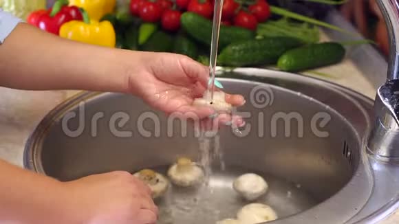 一个女人在水槽里用自来水冲洗蘑菇视频的预览图