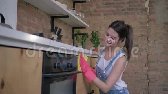 幸福管家微笑家庭主妇女性戴着橡胶手套在厨房和视频的预览图