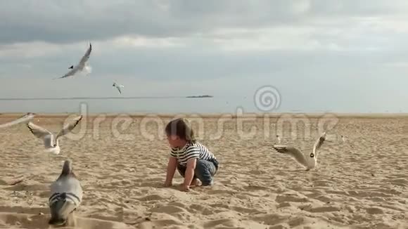 穿着条纹T恤的孩子在海边沙滩上奔跑视频的预览图