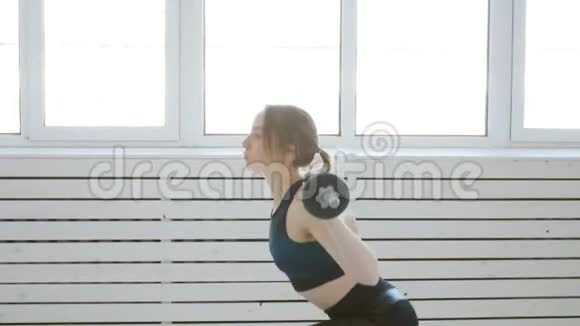 家庭健身理念有杠铃的年轻女子在白色的室内运动视频的预览图