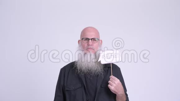 快乐成熟的秃头男人微笑着拿着自拍纸标志视频的预览图