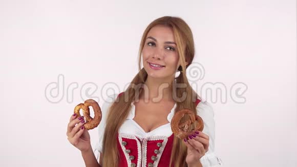 穿着啤酒节礼服的漂亮德国女人抱着椒盐卷饼看上去很兴奋视频的预览图