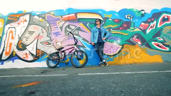 一个年轻的青少年带着一辆BMX自行车的肖像底部视图视频的预览图