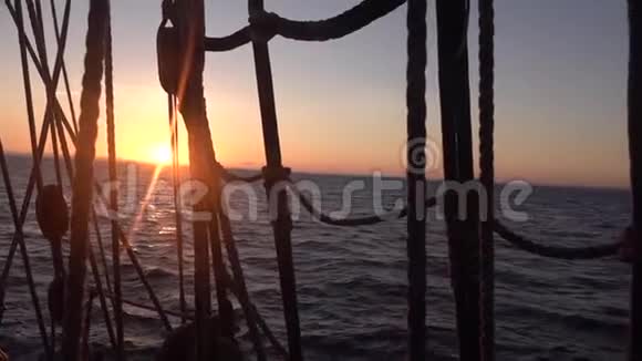 太阳落山穿过一艘旧帆船的船罩和帆索视频的预览图
