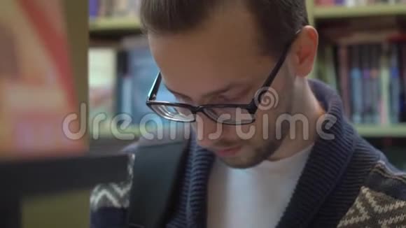 图书馆或书店里的年轻人戴直眼镜视频的预览图