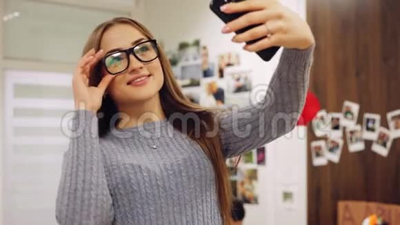 迷人的女人戴着眼镜在相机里微笑在漂亮的办公室里自拍视频的预览图