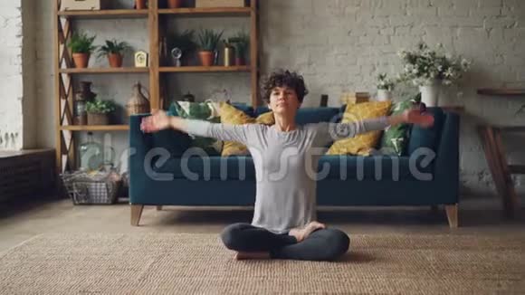 在运动服装中用双手坐在莲花的位置然后放在Namaste中吸引人的女孩的肖像视频的预览图