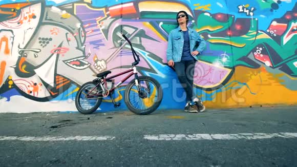 吸引人的少年画像年轻的骑自行车的男子站在墙边骑自行车视频的预览图