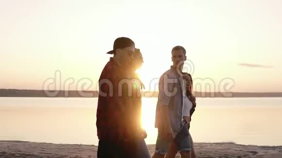 侧观年轻好朋友共度时光傍晚漫步在沙滩上两对情侣约会视频的预览图