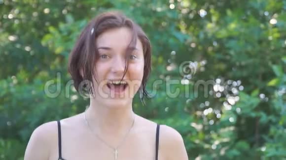 女孩在绿叶的背景下鬼脸和笑话视频的预览图