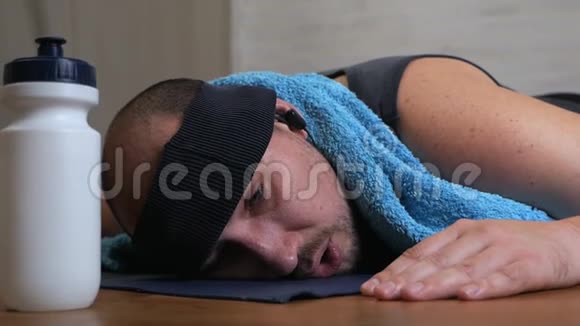 有趣的胖子在瑜伽垫上厌倦了上课用水冷却自己视频的预览图