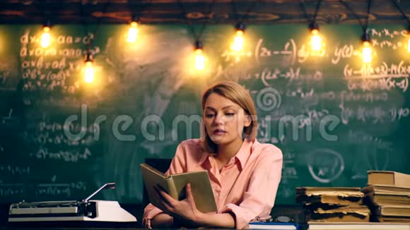 老师有兴趣在一个绿色学校董事会的背景下在学校教室里读一本书教师视频的预览图