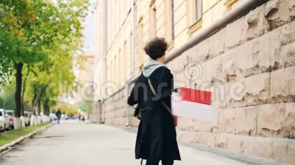 慢镜头描绘一个快乐的卷发女孩她手里拿着购物袋笑转身视频的预览图