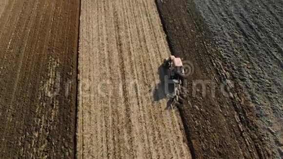 一个拖拉机上的农民为早春季节准备土地农业用地工作顶部视图视频的预览图