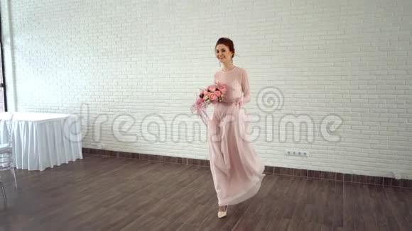 美丽的新娘穿着粉红色的裙子带着彩色的新鲜玫瑰花束视频的预览图