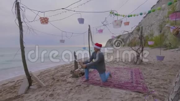 一个在海上戴圣诞帽的人打开一瓶香槟视频的预览图