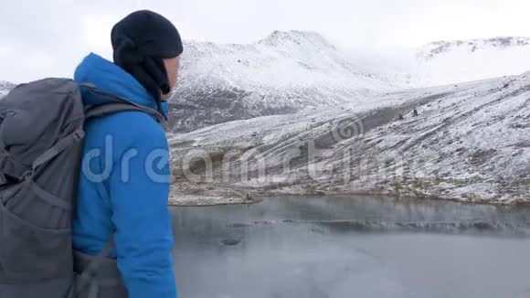 体育摄影师背着背包在山里旅行他用相机拍摄美丽的风景视频的预览图