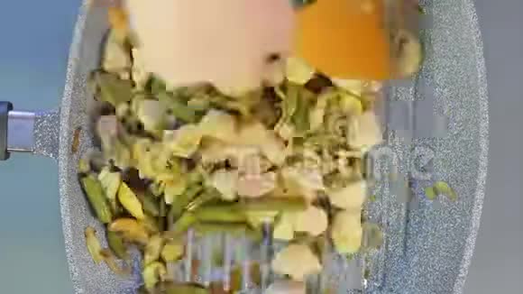 一个女人用木铲豆子和蘑菇混合在一起用鸡块和酱油烤着视频的预览图