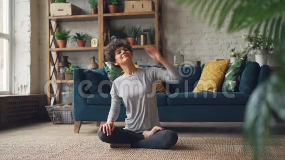 美丽的女人完成了她的瑜伽练习在莲花的位置放松双手跪着呼吸享受着视频的预览图