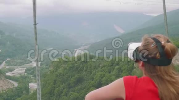 夏天在高山外戴虚拟现实护目镜的年轻女子虚拟现实眼镜视频的预览图