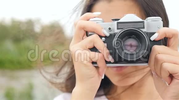 一个漂亮的女孩拿着相机拍照特写视频的预览图