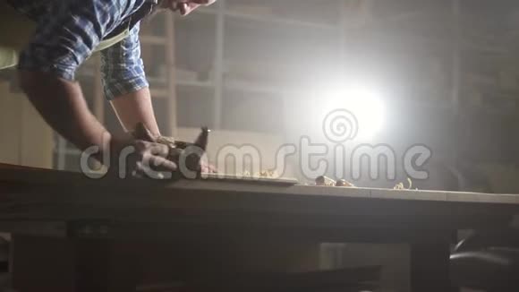 黑车间里的男木工头刨木工视频的预览图