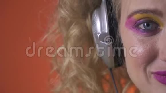 金发女人带着耳机欣赏音乐闭上眼睛视频的预览图