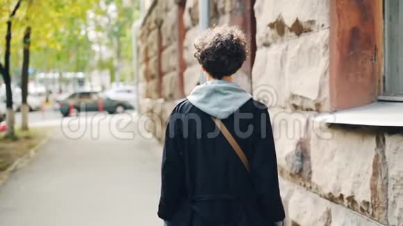慢镜头肖像美丽苗条女孩走在街上然后转身看着相机和微笑青年视频的预览图