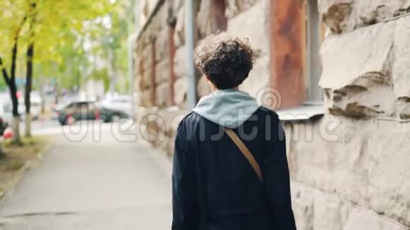 慢镜头描绘一个美丽的黑发女郎她背对着镜头走在街上然后转过身来微笑着视频的预览图