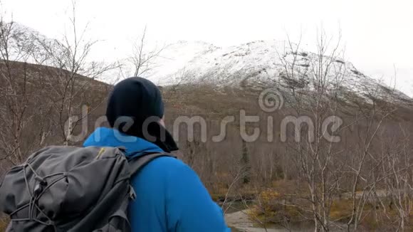 一个背着背包的人看着山在他面前是一道美丽的风景积极的生活旅行和冒险视频的预览图