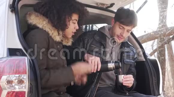 冬天一对夫妇在汽车后备箱里喝热咖啡视频的预览图