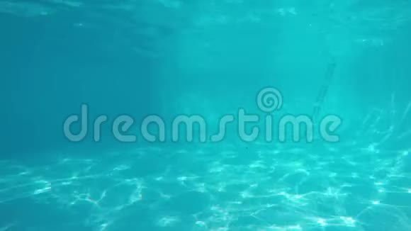 三个白种人比基尼女孩在蓝色游泳池的镜头前游泳从水下观看视频的预览图