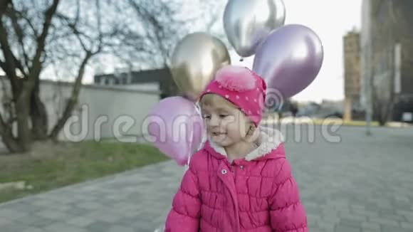 快乐可爱的孩子在街上拿着气球和氦生日聚会视频的预览图