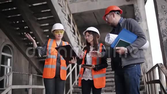工头和两名女视察员讨论建造或恢复建筑的工作计划视频的预览图