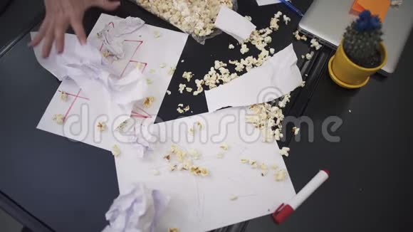 女人的手撕爆米花和皱巴巴的纸视频的预览图