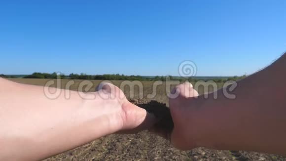 在阳光明媚的日子里农民的男性手握着一堆干土用手指倒在田野上概念视频的预览图