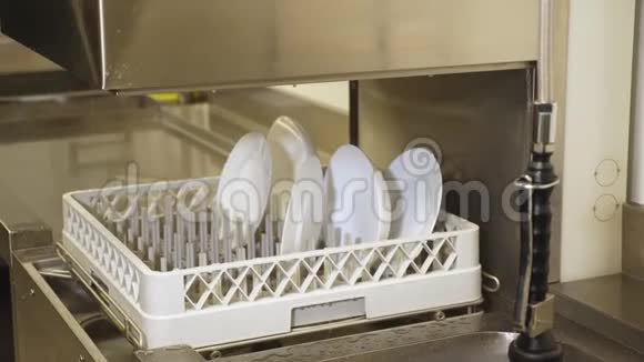 关闭在自动洗碗机的篮子上的白色盘子用于工业洗碗机在厨房自助餐厅视频的预览图