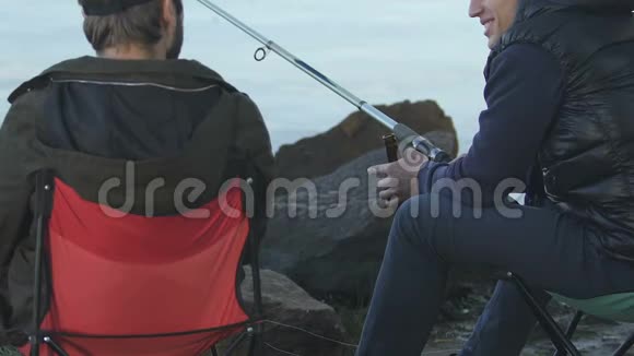 男性朋友一起享受钓鱼喝啤酒的乐趣视频的预览图