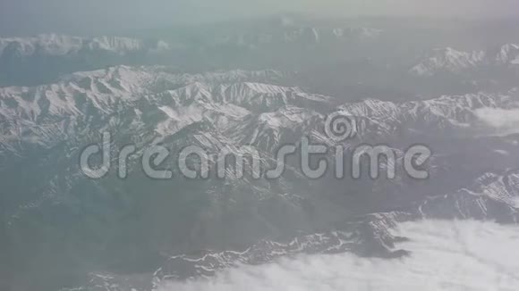 鸟瞰雪山云海从飞机上看山上的褶皱山顶覆盖着视频的预览图