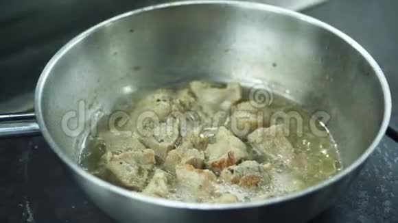 特写厨师在炉子上准备不同的食物锅里炖肉潘专业厨师烤洋葱视频的预览图