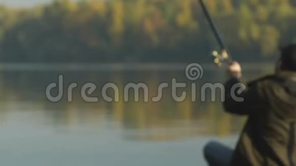 渔人钓鱼坐在河岸上爱好娱乐视频的预览图
