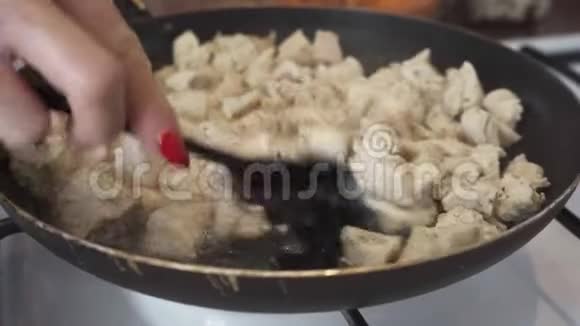 鸡片放入煎锅中煎煮搅拌视频的预览图