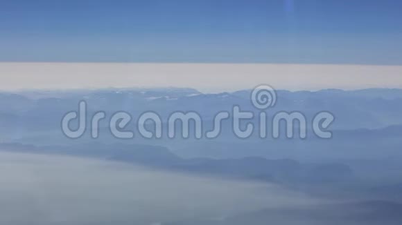 从上面俯瞰山脉和云层就像从飞机窗户看到的那样视频的预览图