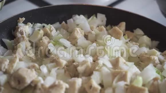 鸡片和切碎的洋葱在平底锅特写中煮熟视频的预览图