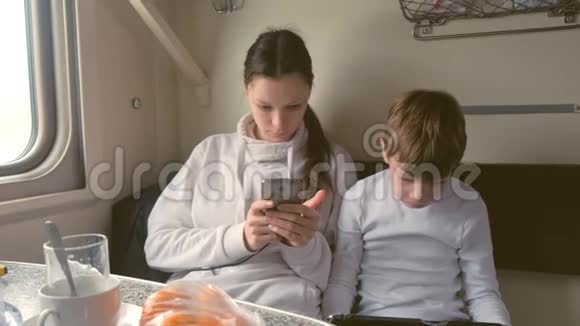 坐火车旅行的小玩意里的妈妈和儿子正在乘坐二等车厢玩游戏视频的预览图