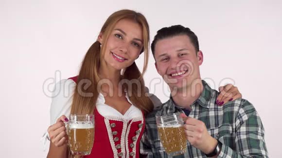 快乐啤酒节的一对情侣咯咯地喝着啤酒杯彼此微笑视频的预览图