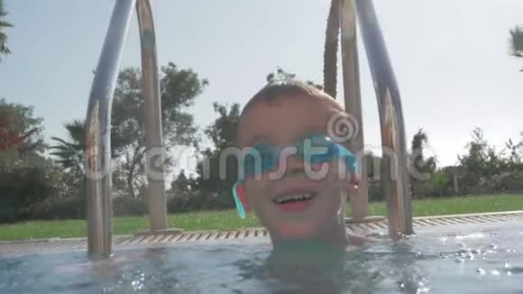 一个快乐的男孩在一个开放的游泳池里缓慢的动作视频的预览图